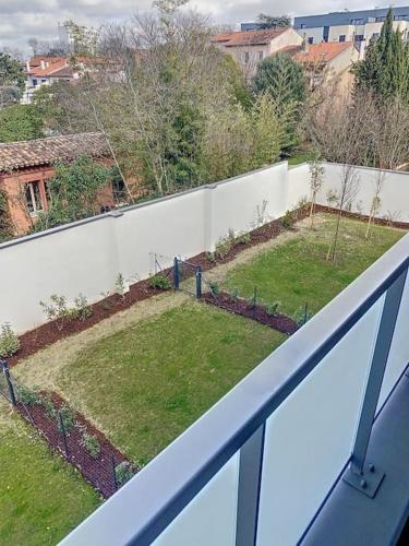 a view of a garden on a white fence at CAPRI - Sublime T2 Patte d'oie (Netflix, Terrasse) in Toulouse
