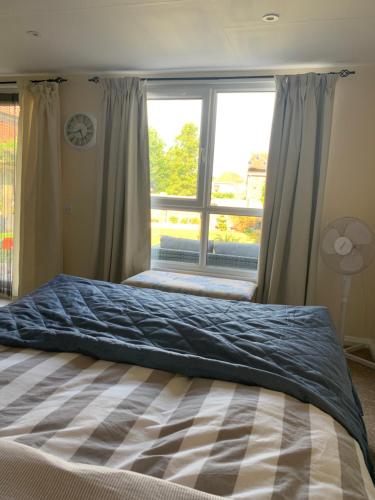 a bedroom with a bed with a large window at Pet friendly, disabled friendly cabin close to the humber and immingham in Goxhill