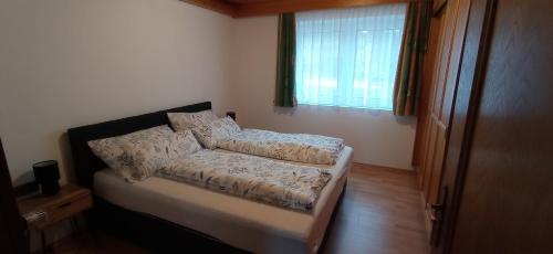ein kleines Bett in einem Zimmer mit Fenster in der Unterkunft Haus Elli in Greifenburg