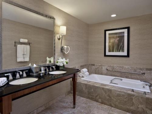 un bagno con 2 lavandini e una vasca di Loews New Orleans Hotel a New Orleans