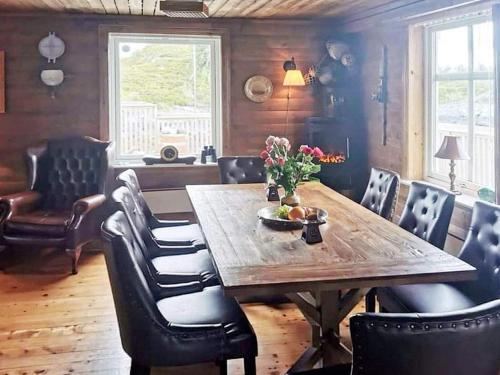 comedor con mesa de madera y sillas en Holiday home Flatraket IV 