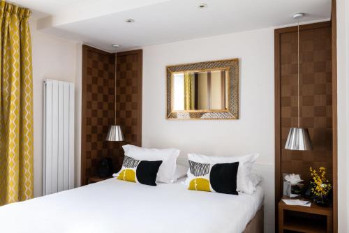 a bedroom with a bed and a mirror on the wall at Hôtel Le Colisée in Paris