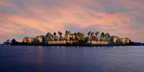 a large building on an island in the water at sunset at Loews Coronado Bay Resort in San Diego