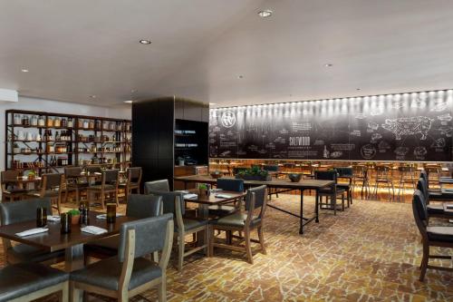 a restaurant with tables and chairs and a wall withcriptions at Loews Atlanta Hotel in Atlanta