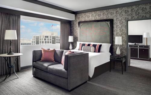 a hotel room with a bed and a couch at Loews Nashville Hotel at Vanderbilt Plaza in Nashville