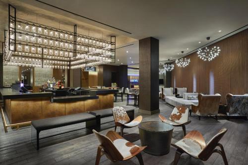 a lobby of a hotel with a bar and chairs at Loews Nashville Hotel at Vanderbilt Plaza in Nashville
