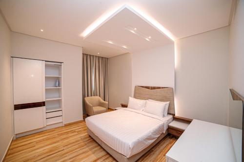 ein kleines Schlafzimmer mit einem Bett und einem Stuhl in der Unterkunft JC SUITES in Manama