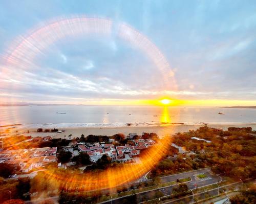a view of a city with the sun setting over the water at Shangri-La Xiamen in Xiamen
