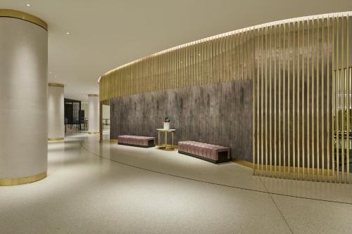 a lobby with pink benches and a wall with at Loews Miami Beach Hotel in Miami Beach