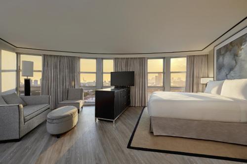 a bedroom with a bed and a couch and a chair at Loews Miami Beach Hotel in Miami Beach