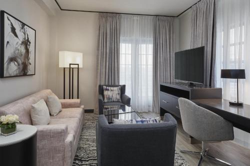a living room with a couch and a tv at Loews Miami Beach Hotel in Miami Beach