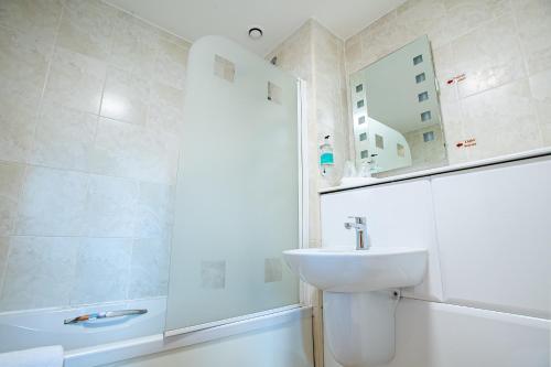 a white bathroom with a sink and a shower at Castlefield Hotel in Manchester