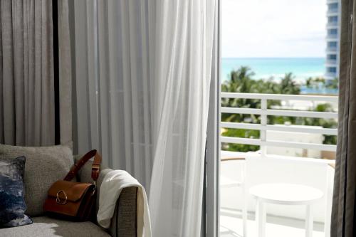 a purse sitting on a chair in front of a window at Loews Miami Beach Hotel in Miami Beach