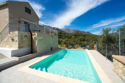 a swimming pool in front of a house at Villa Cretan View with Heated Swimming Pool in Pátima