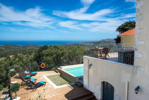 a view from the balcony of a house with a swimming pool at Villa Cretan View with Heated Swimming Pool in Pátima