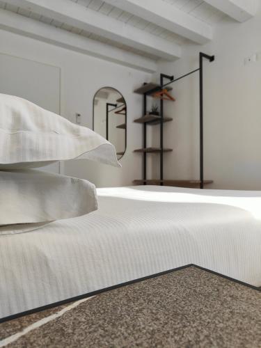 a bed with white sheets and pillows in a room at Borgo di Ponte Holiday Apartments & Rooms in Cividale del Friuli