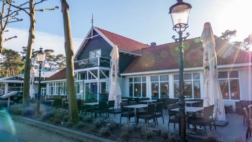 a building with tables and chairs and a street light at Comfort Rooms by EuroParcs de Zanding in Otterlo