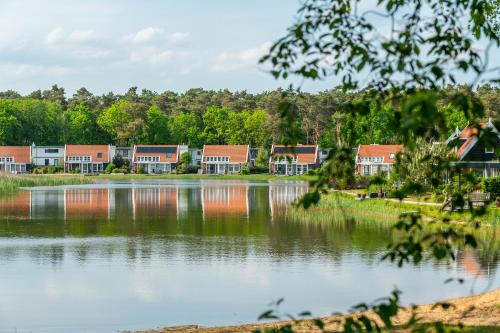 a row of houses on the shore of a lake at Comfort Rooms by EuroParcs de Zanding in Otterlo