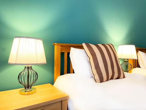 a bedroom with two beds and a table with two lamps at Catcune Superior Suite in Gorebridge
