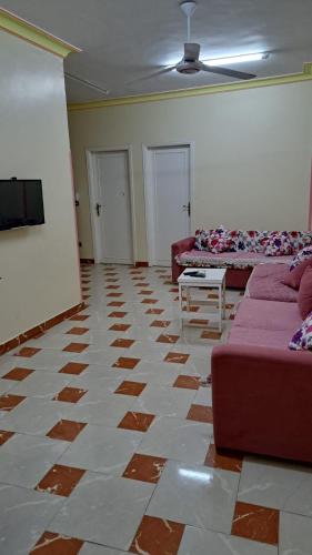een woonkamer met 2 banken en een tv bij Sweet Home- No Egyptian in Hurghada