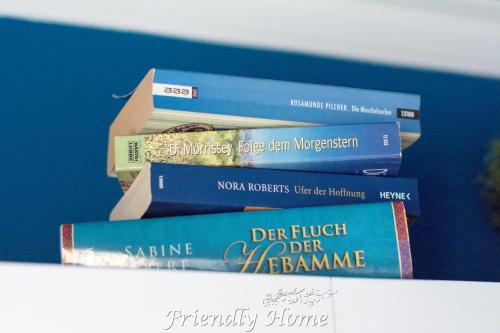 a stack of books sitting on top of a shelf at Friendly Home - Einzelappartement "Trust" Köln Bonn Phantasialand in Brenig