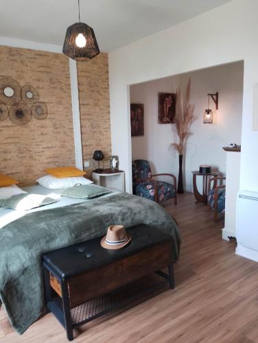 - une chambre avec un lit et un chapeau sur une table dans l'établissement La Ménardière Serenitatis chambre d'hôtes petit déjeuner compris, à Corseul