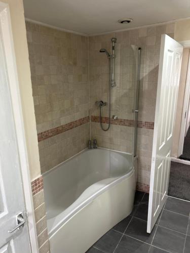 a white bath tub in a bathroom with a shower at The Pickwick Inn in Kingsbridge