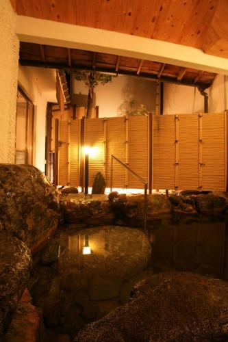 a house with a pond in front of a building at Kaichoen in Yonago