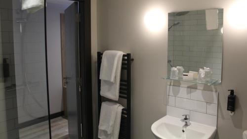 a bathroom with a sink and a glass shower at Marine Hotel Ballycastle in Ballycastle