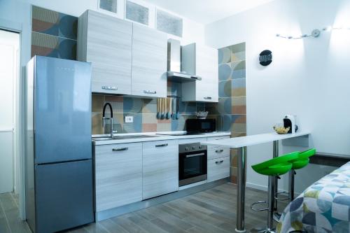 a kitchen with white cabinets and a green stool at STUDIO 47 - CITY LIFE in Milan