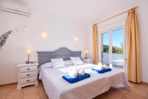 a bedroom with a bed with two blue pillows on it at Monte Rosa in Jávea