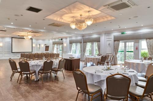 a conference room with tables and chairs and a podium at Burnham Beeches Hotel & Spa in Windsor