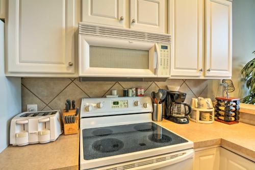a kitchen with a white stove and a microwave at 2 Pools Waterfront Condo on Lake of the Ozarks! in Camdenton