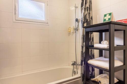 y baño con ducha, bañera y toallas. en Casa da Olides - T3 en Santana