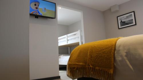 a bedroom with a bed and a tv on a wall at Marine Hotel Ballycastle in Ballycastle