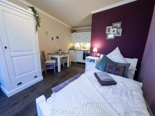 een slaapkamer met een wit bed en een keuken bij Friendly Home - Einzelappartement "Calm" Köln Bonn Phantasialand in Brenig