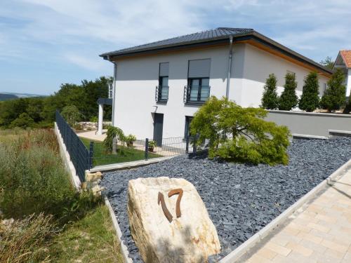 une maison avec un grand rocher en face dans l'établissement Lydieline, à Wincheringen