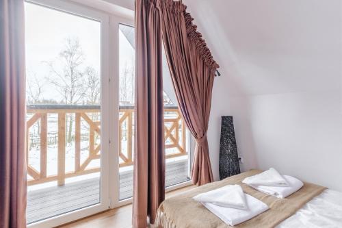 a bedroom with a bed and a large window at Folk Vibe in Białka Tatrzanska
