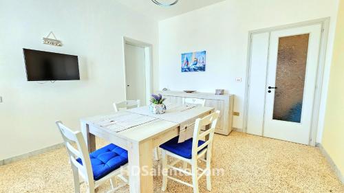 a dining room with a wooden table and chairs at Casa Lores - Fronte Mare Pescoluse in Marina di Pescoluse