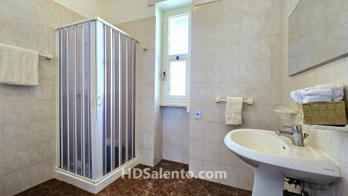 a bathroom with a sink and a glass shower at Casa Lores - Fronte Mare Pescoluse in Marina di Pescoluse