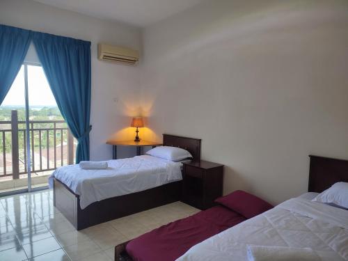 a hotel room with two beds and a balcony at Sofea Inn Bukit Merah - Suria A7727 in Kampong Selemat