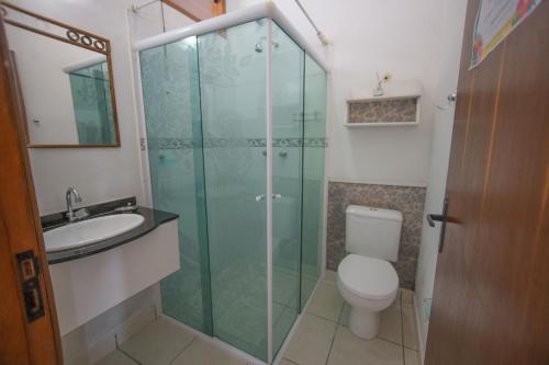 a bathroom with a shower and a toilet and a sink at Pousada Ventos de Outono in São Roque
