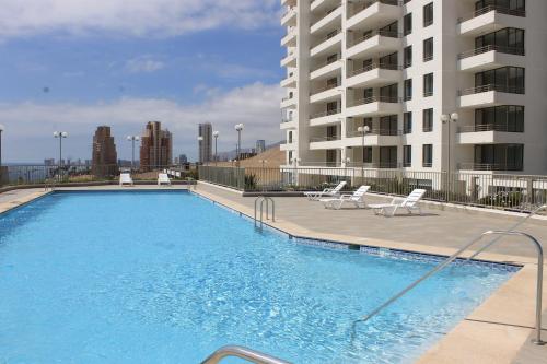 a large swimming pool in front of a building at Apartamento Altos de Huayquique in Iquique