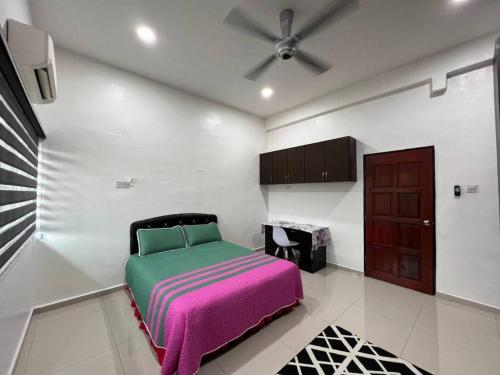 Schlafzimmer mit einem Bett und einem Deckenventilator in der Unterkunft One's Homestay in Seri Manjung