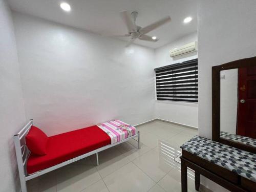 Cette chambre comprend un lit rouge et un miroir. dans l'établissement One's Homestay, à Seri Manjung