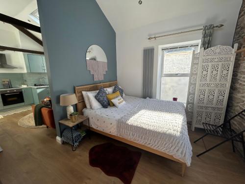 una camera da letto con un letto e un piumone bianco di Heart of Falmouth - Entire Studio Apartment a Falmouth