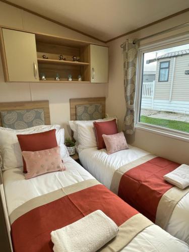 two beds in a small room with a window at Abi in St Austell
