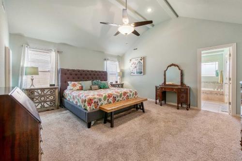 a bedroom with a bed and a table and a ceiling fan at Near Hiking and Biking Convenient Home in Rogers! in Rogers