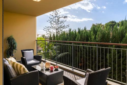 a balcony with chairs and a table with a view at Comboio I by An Island Apart in Funchal