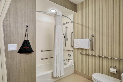 La salle de bains est pourvue d'une douche avec rideau de douche blanc. dans l'établissement Courtyard by Marriott North Brunswick, à North Brunswick